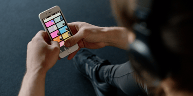 man holding phone with spotify categories on screen